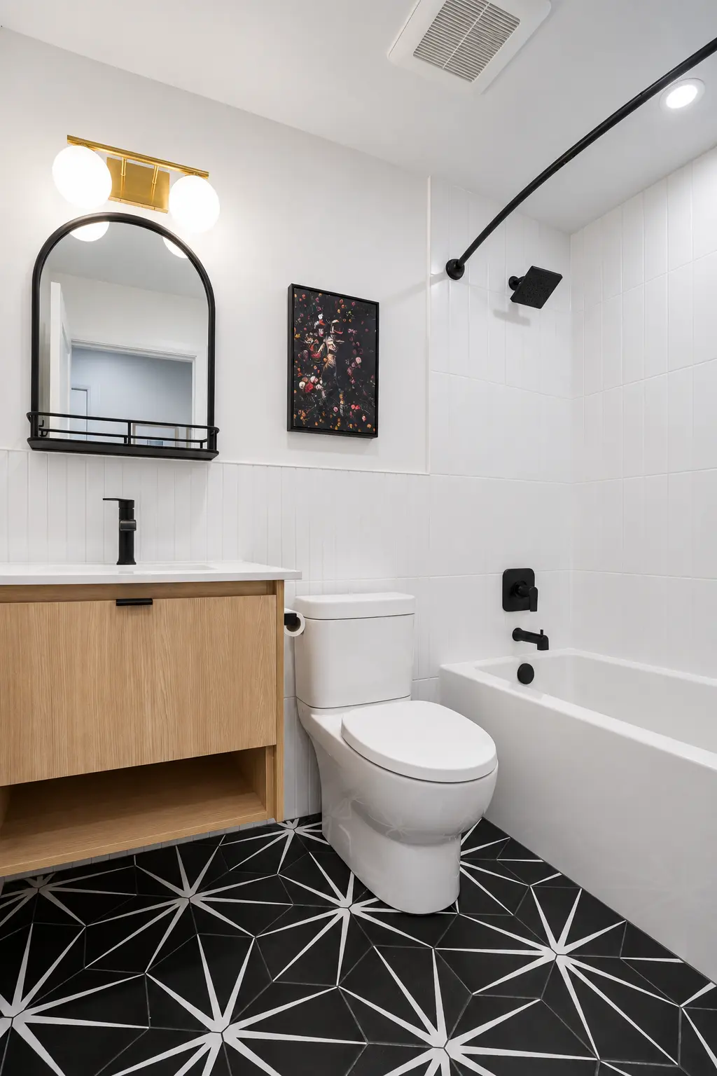 Completed compact bathroom with graphic floor tile and warm wood vanity