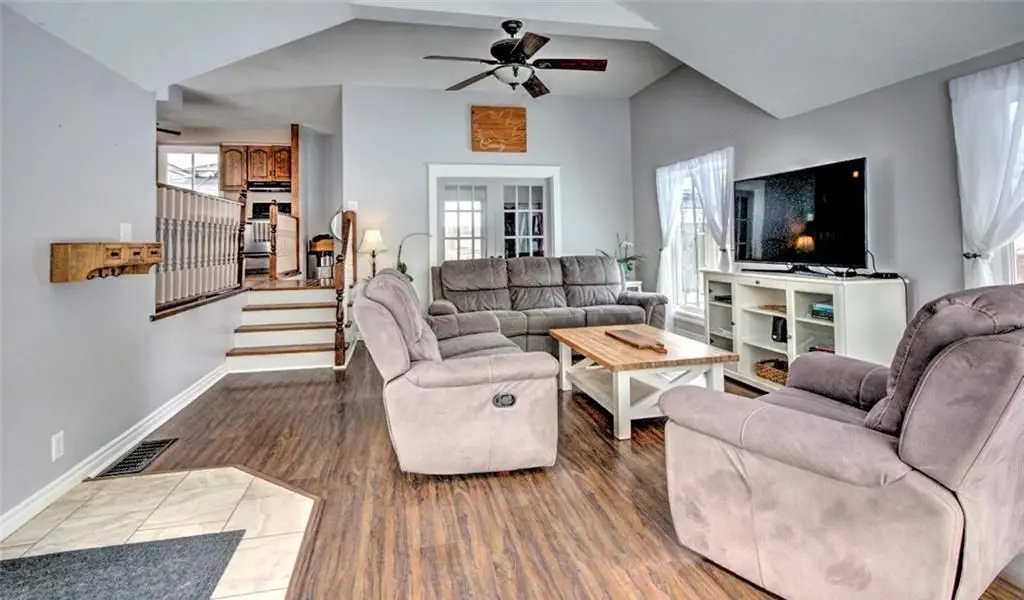 Living room before renovation with a closed staircase and darker finishes