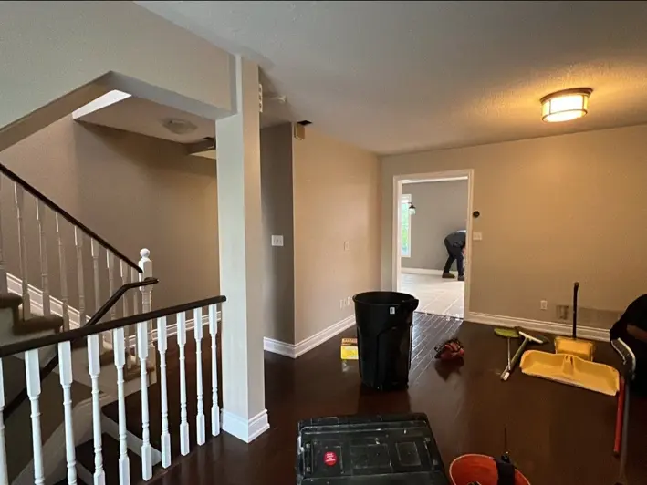 Main floor before renovation, with a closed layout, columns and stair railings